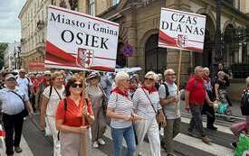Seniorzy z Gminy Osiek na Senioraliach w Krakowie z transparentami. 