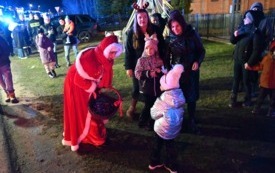 Orszak Świętego Mikołaja z mieszkańcami Długołęki, Pani Burmistrz Miasta i Gminy Osiek Magdalena Marynowska częstuje cukierkami najmłodszych mieszkańc&oacute;w. 