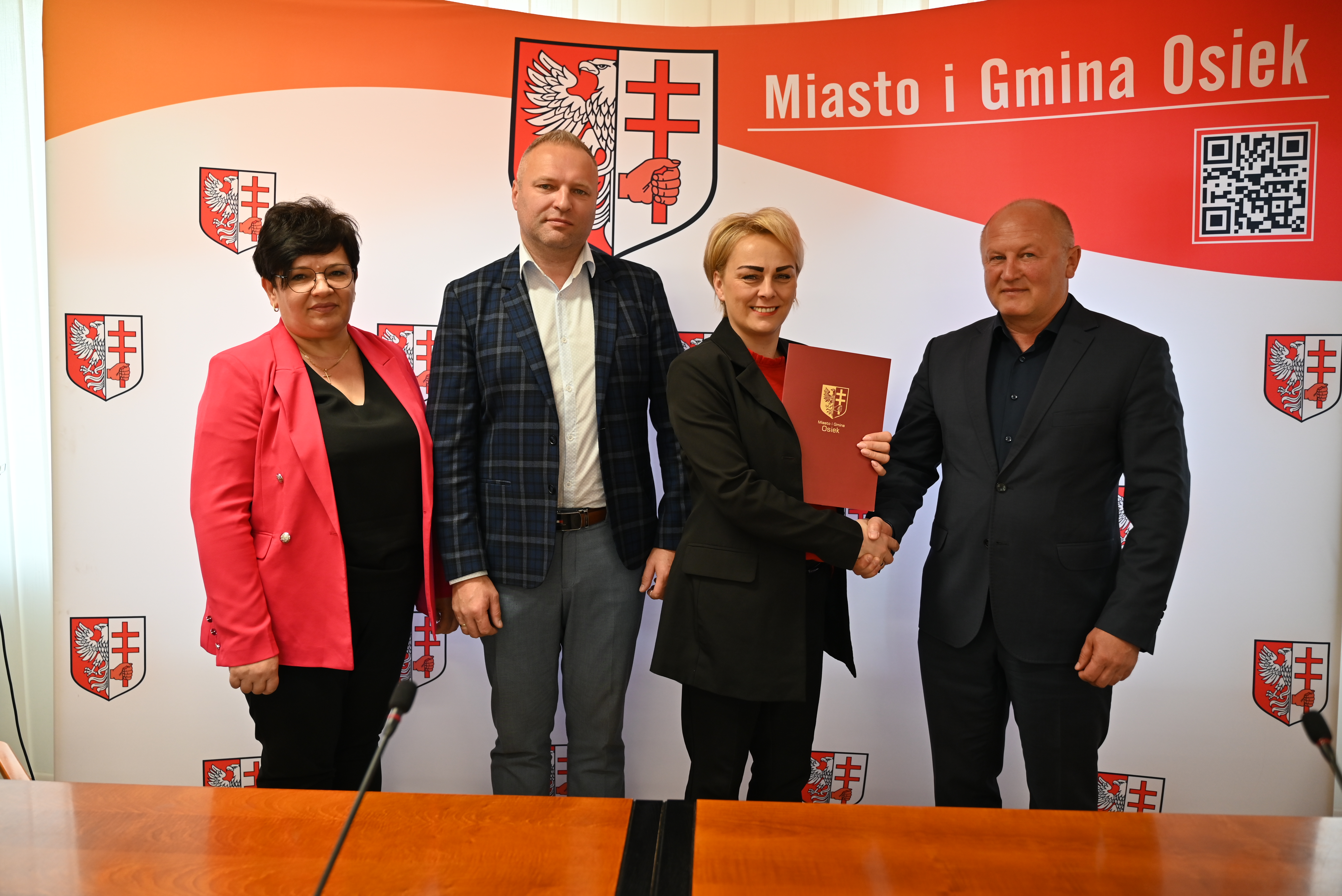 Chwila po podpisaniu umowy na&nbsp;realizację żłobka samorządowego, zdjęcie pamiątkowe na&nbsp;ściance 